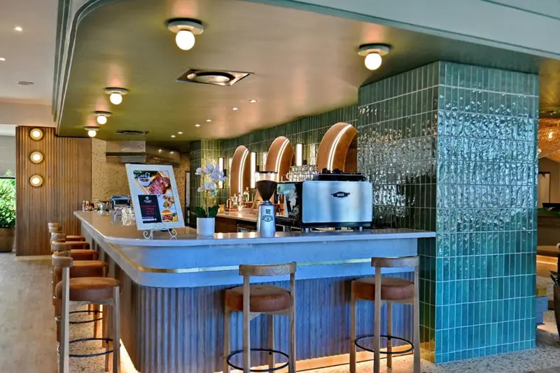 Un comptoir de bar moderne avec des tabourets et une machine à café.