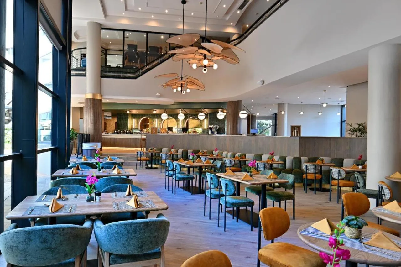 Une salle lumineuse avec des tables dressées pour le repas.