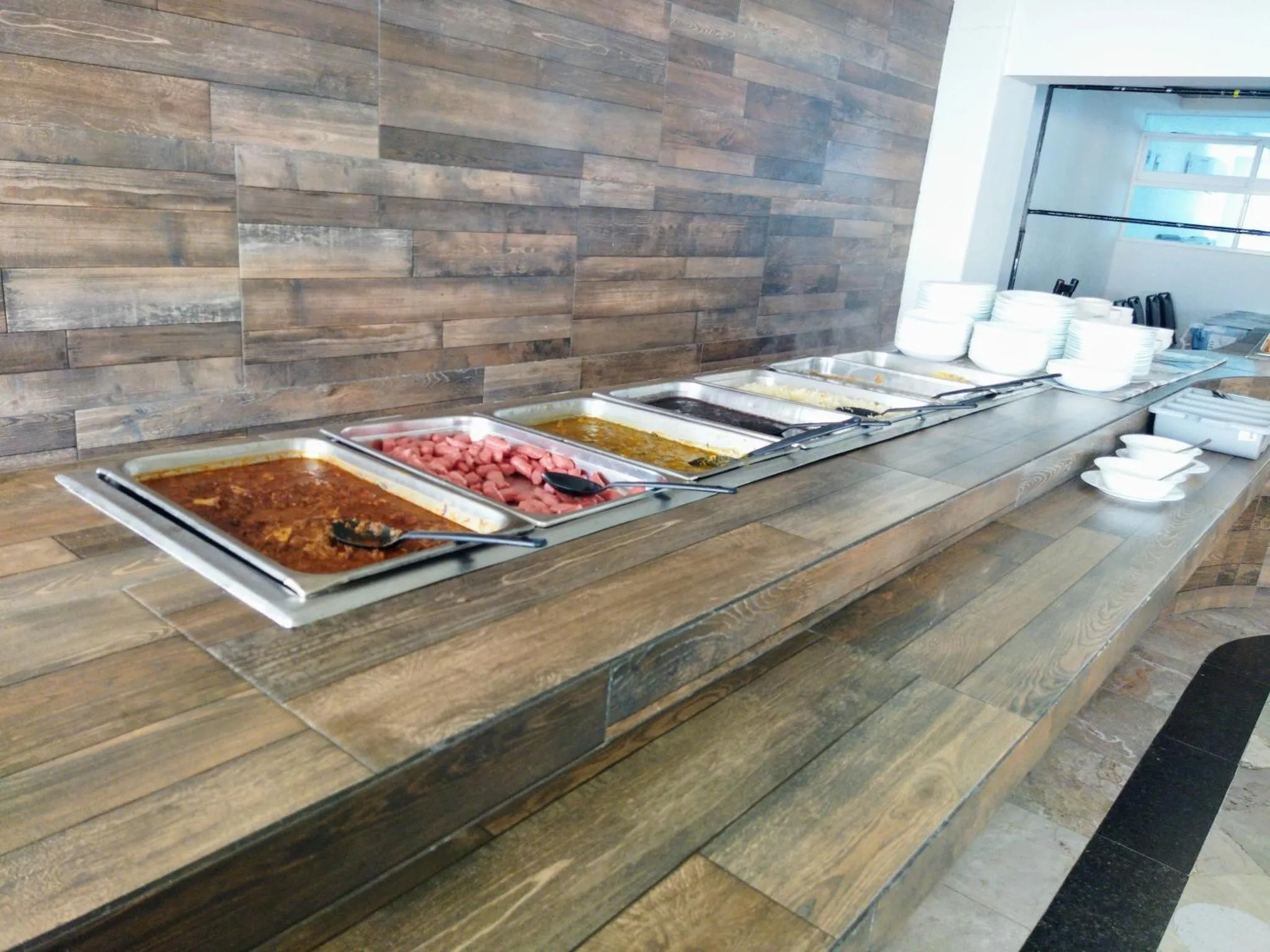 Un buffet propose une variété de plats chauds et de salades.