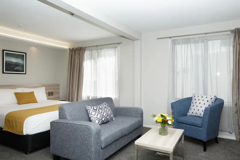 Une chambre lumineuse avec un canapé et un fauteuil.
