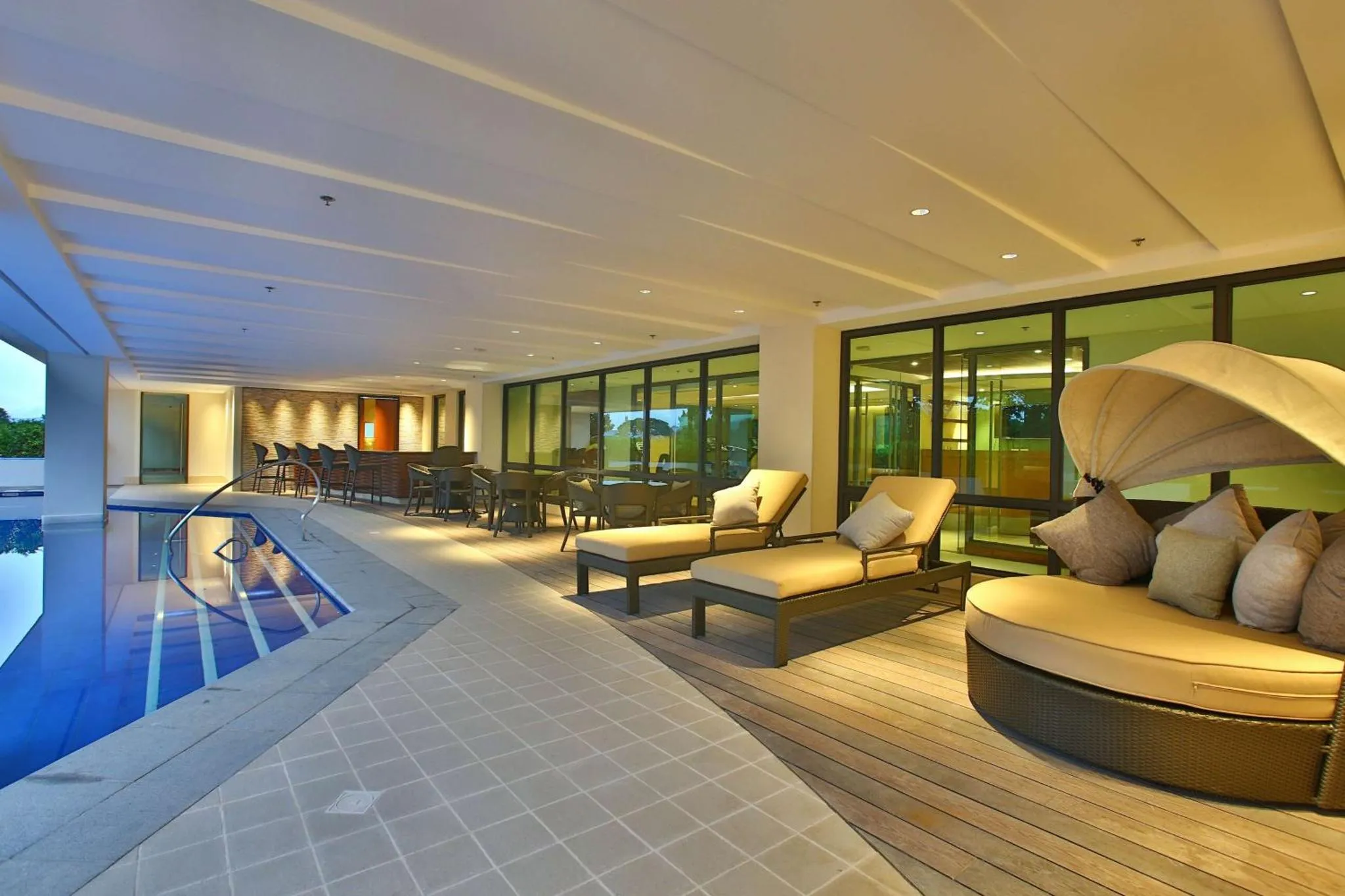 Espace de détente extérieur avec transats et salon de jardin près d'une piscine.