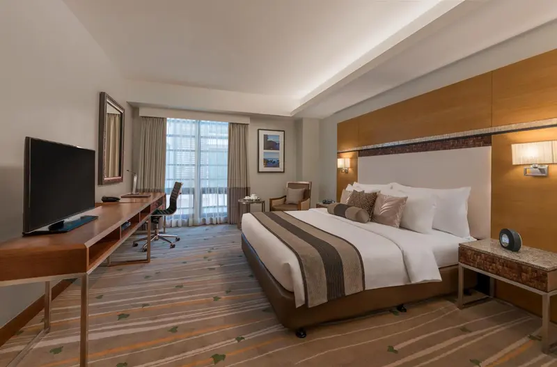 Une chambre d'hôtel lumineuse avec un grand lit et un bureau.