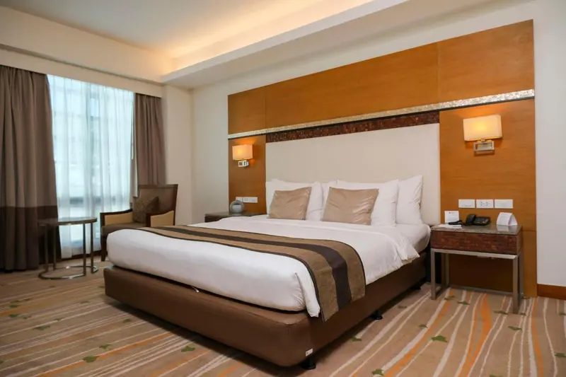 Une chambre d'hôtel moderne avec un grand lit et un fauteuil.