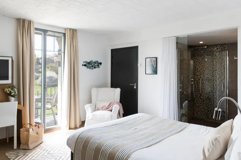 Chambre lumineuse avec un lit confortable et un accès à une terrasse.