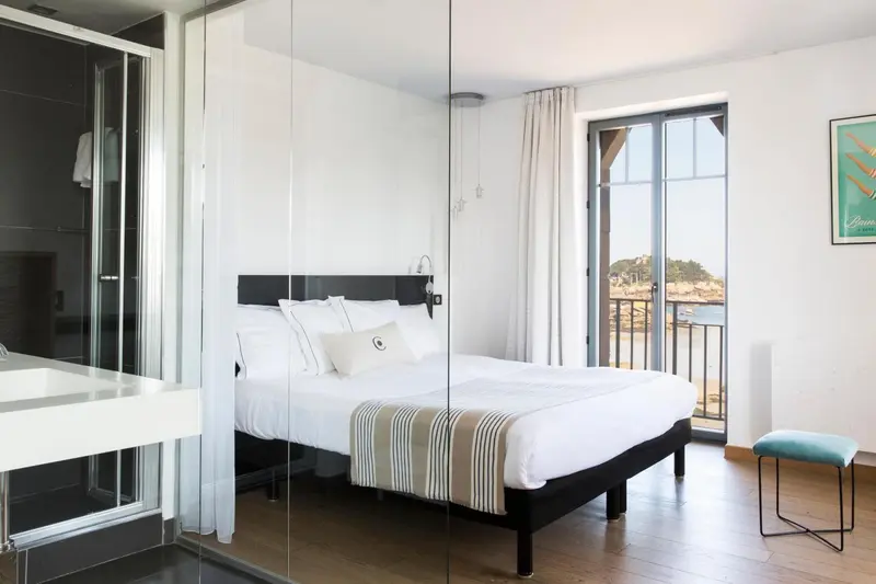 Une chambre lumineuse avec un grand lit et une vue sur la mer.