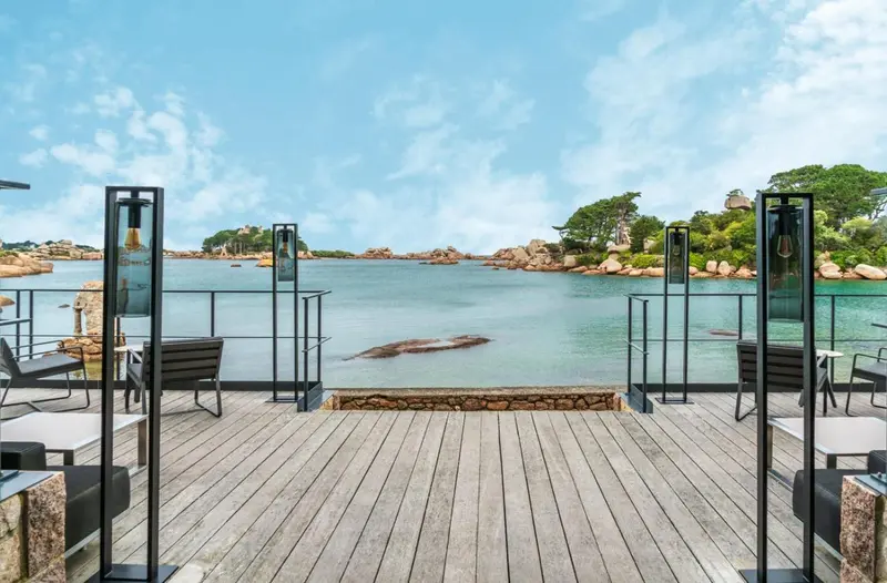 Terrasse en bois avec mobilier d'extérieur donnant sur une baie abritée.