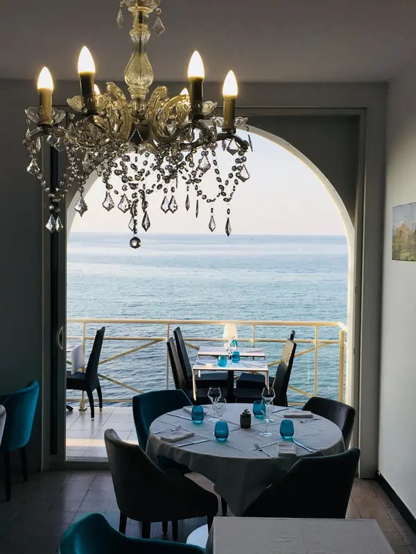 Une salle à manger lumineuse s'ouvre sur une vue sur la mer.