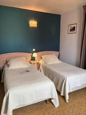 Une chambre avec deux lits simples et un mur bleu.