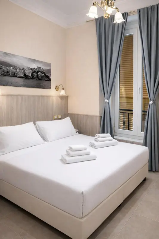 Une chambre lumineuse avec un grand lit recouvert de linge blanc.