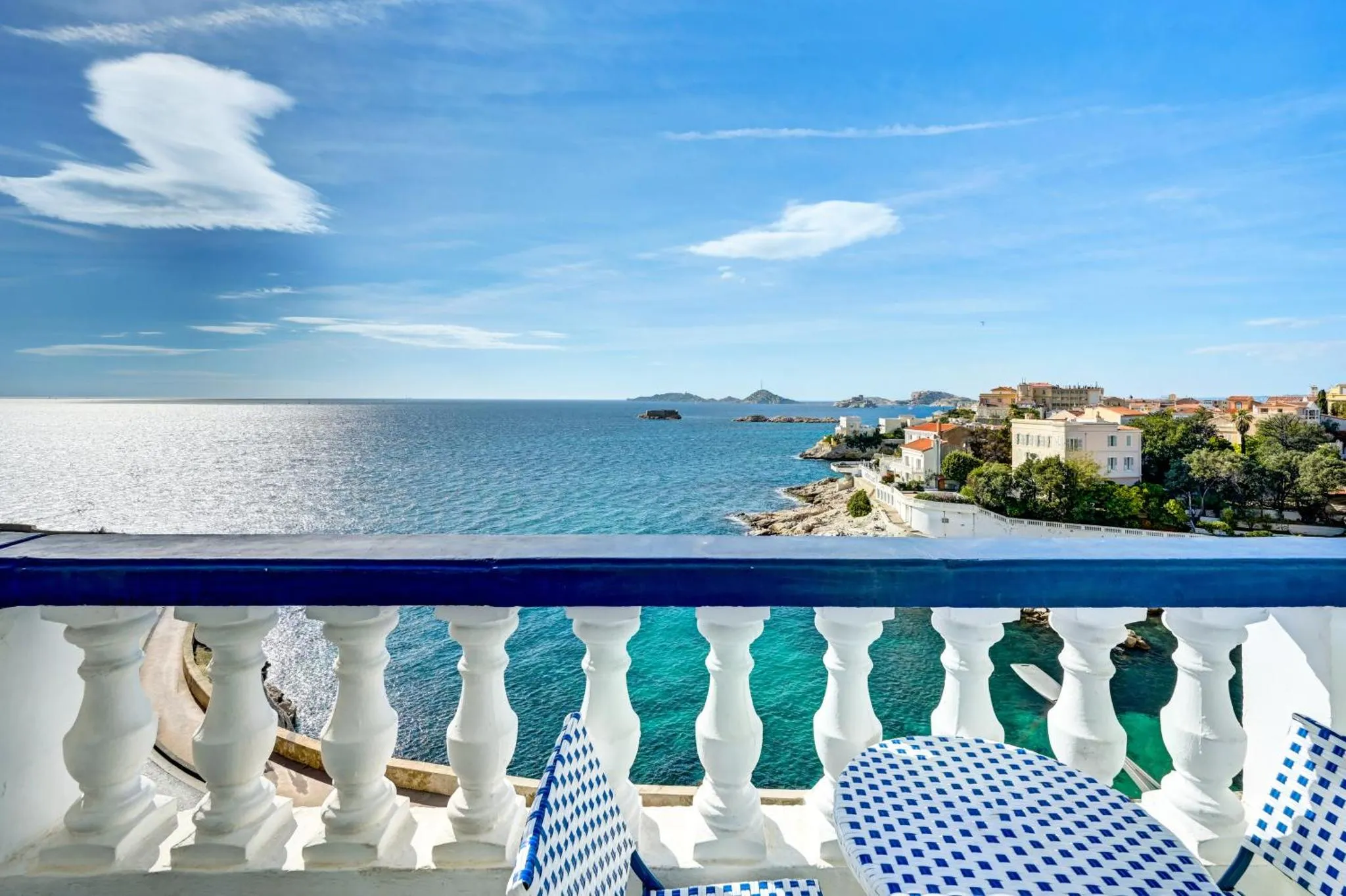 Vue sur la mer depuis un balcon avec une balustrade blanche.