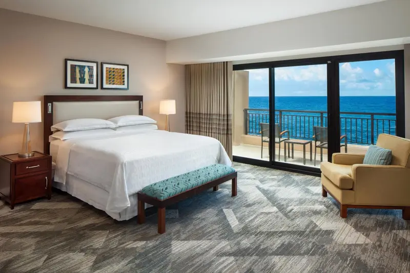 Une chambre lumineuse avec un grand lit et une vue sur la mer.
