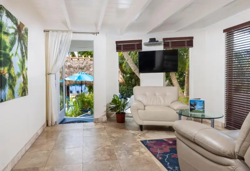 Un espace de détente intérieur avec un canapé et une vue sur une végétation luxuriante.