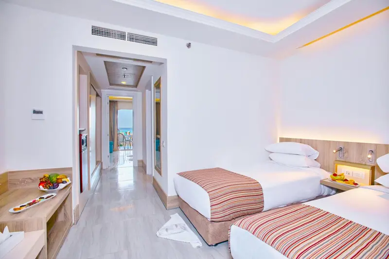 Une chambre lumineuse avec deux lits et un espace repas.