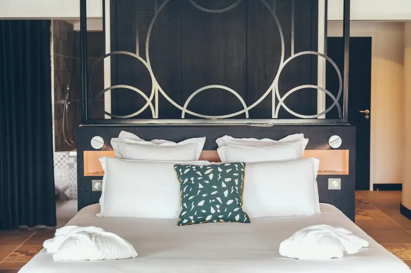 Un lit king-size avec une tête de lit décorative et des oreillers blancs.