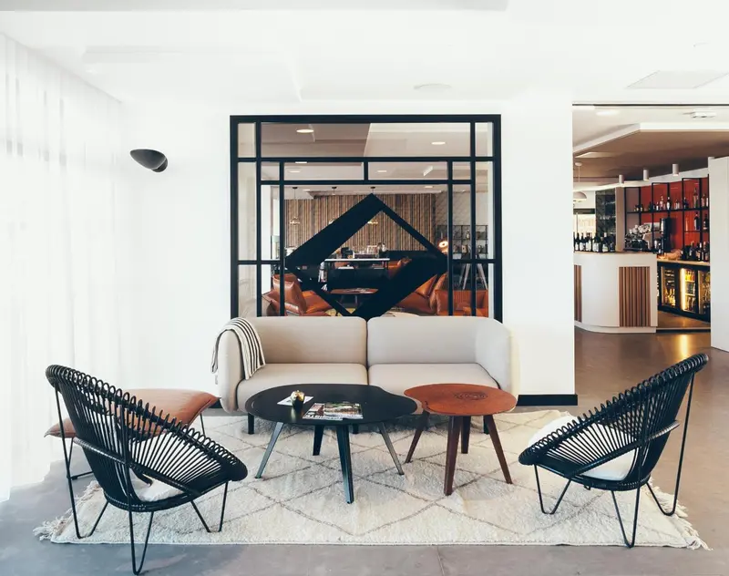 Un espace de détente avec canapés et fauteuils est aménagé avec un tapis et des tables basses.