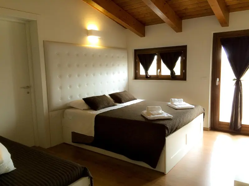 Une chambre lumineuse avec un grand lit et une fenêtre.