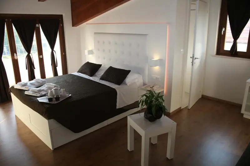 Une chambre moderne avec un grand lit et une décoration sobre.