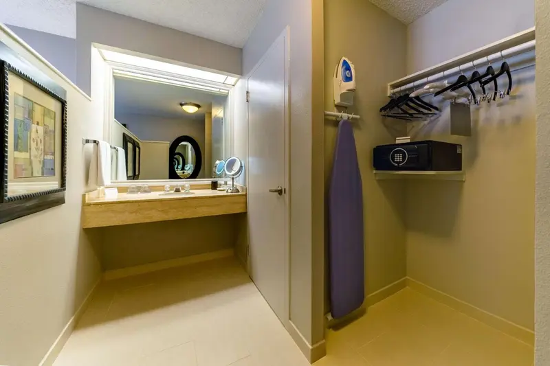 Une salle de bain avec un miroir au-dessus d'un meuble vasque et un espace pour repasser.