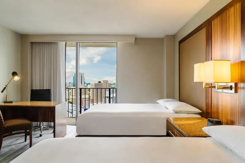 Chambre d'hôtel lumineuse avec vue sur la ville.