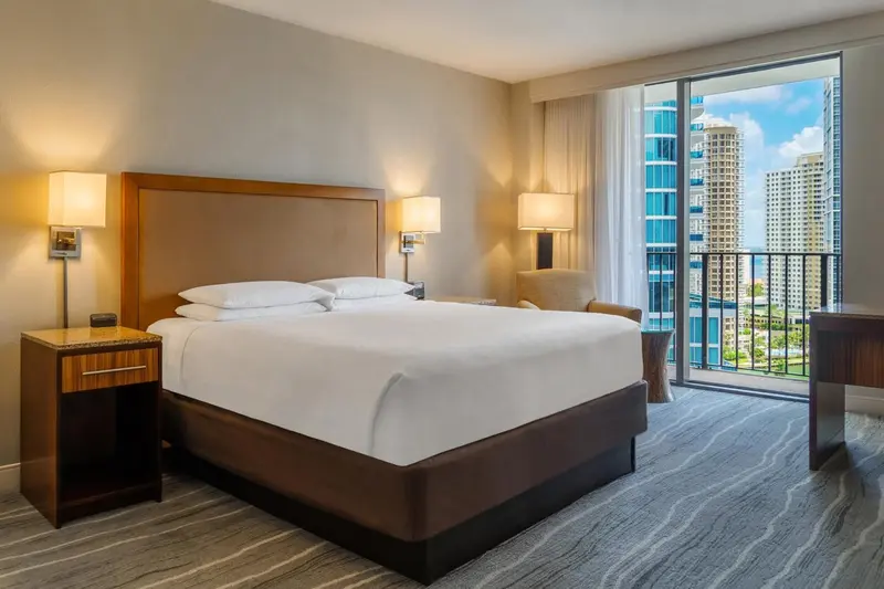 Une chambre d'hôtel lumineuse avec un grand lit et une vue sur la ville.