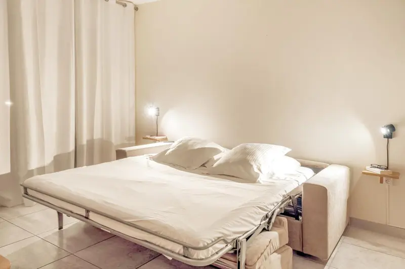 Une chambre lumineuse avec un grand lit et des lampes de chevet.