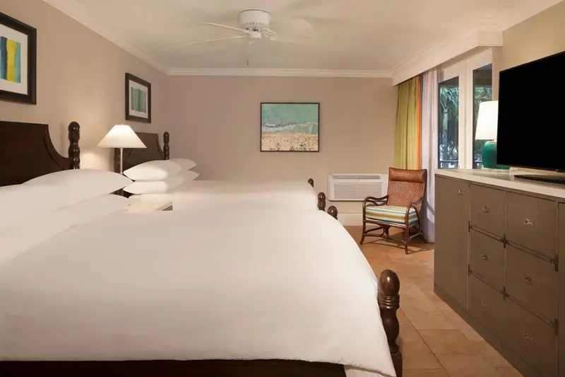 Une chambre lumineuse avec un grand lit et un coin salon.
