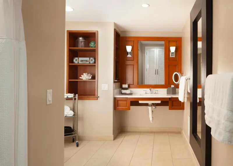 Une salle de bain lumineuse avec un grand miroir et des meubles en bois.