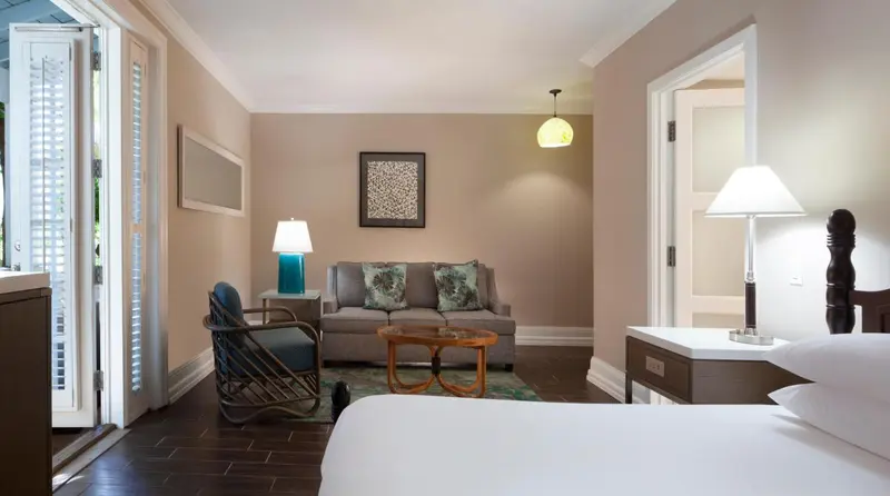 Une chambre lumineuse avec un coin salon et un lit.