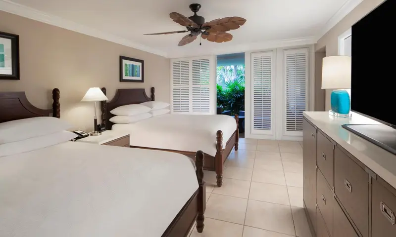 Une chambre lumineuse avec un grand lit et une vue sur la végétation.