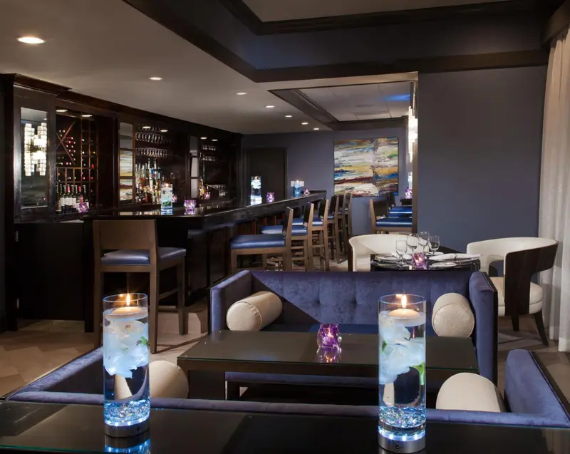 Un bar élégant avec des sièges confortables et une ambiance tamisée.