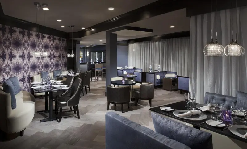 Une salle de restaurant élégante avec des tables dressées et un décor moderne.