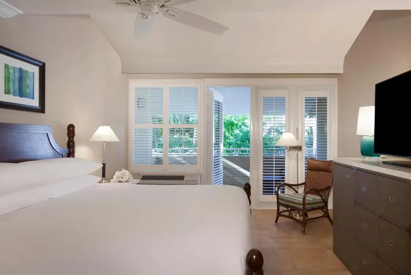 Une chambre lumineuse avec un grand lit et un accès à une terrasse.