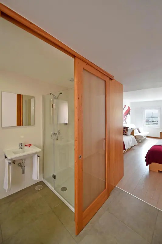 Une salle de bain moderne avec douche à l'italienne et vasque intégrée.