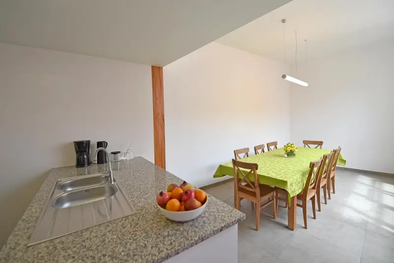 Une cuisine ouverte sur une salle à manger lumineuse.