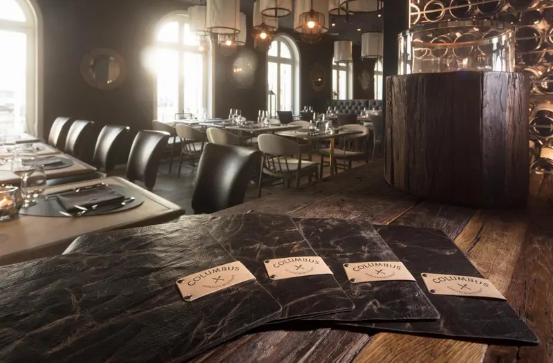 Tables dressées dans une salle à manger élégante avec des menus.