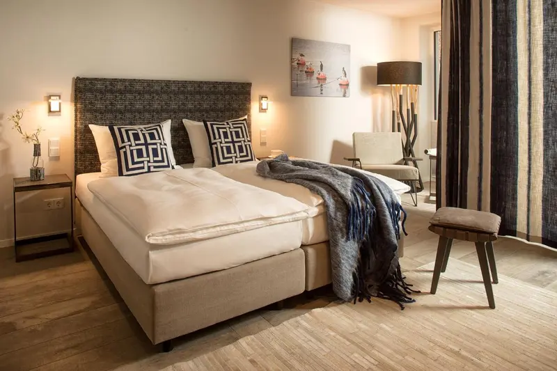 Une chambre lumineuse avec un grand lit et une décoration moderne.