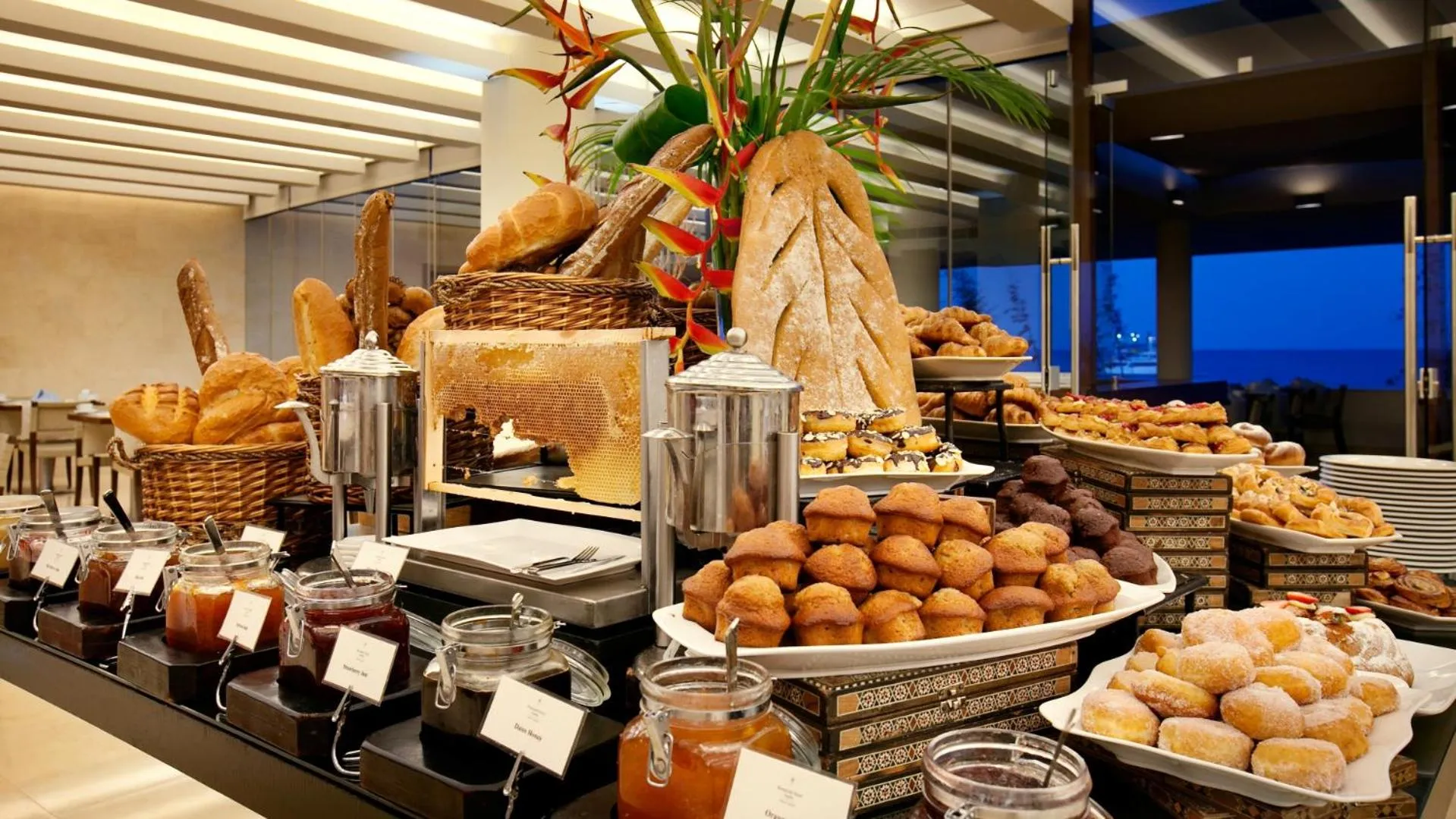 Un buffet propose une grande variété de pains, viennoiseries et confitures.