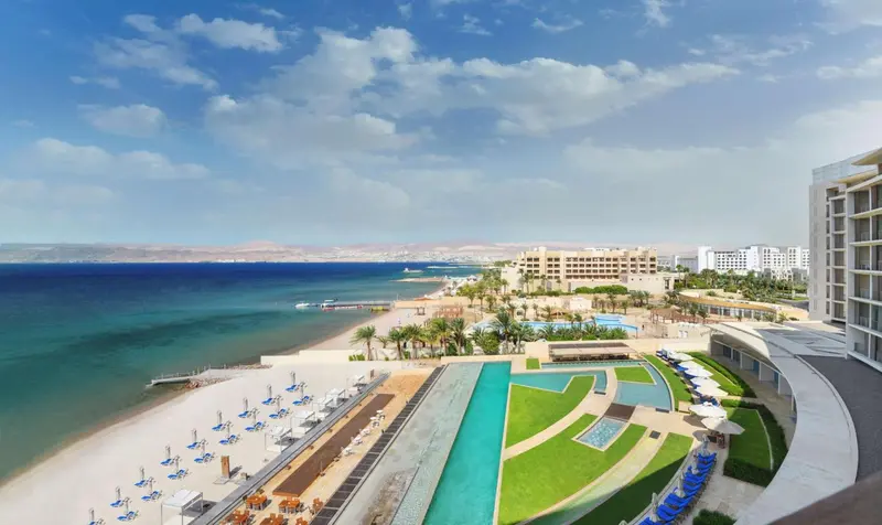 Vue aérienne d'un complexe hôtelier avec piscine et plage.