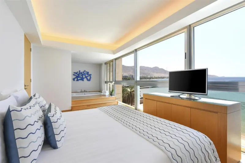 Une chambre lumineuse avec un grand lit et une vue sur la mer.