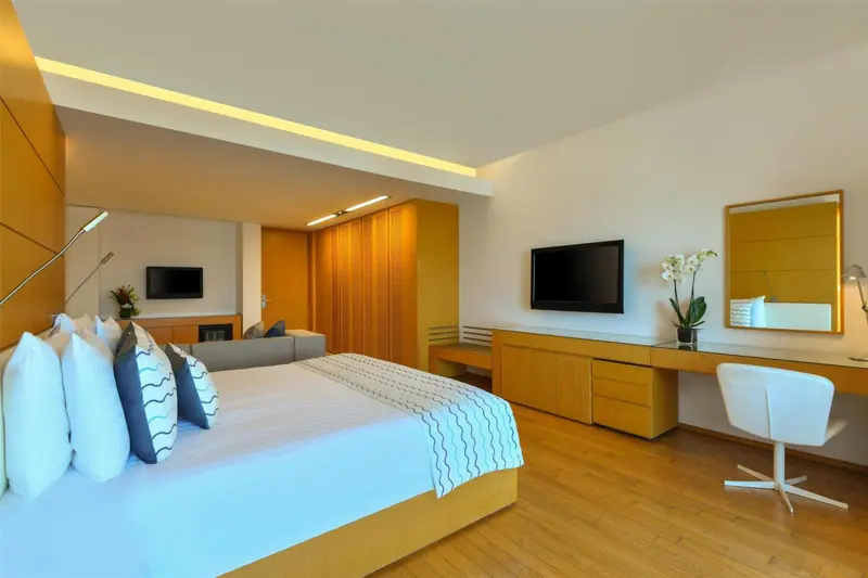 Chambre moderne avec un grand lit et un espace bureau.