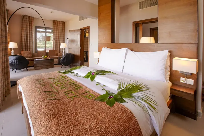Une chambre lumineuse avec un grand lit décoré de fleurs.