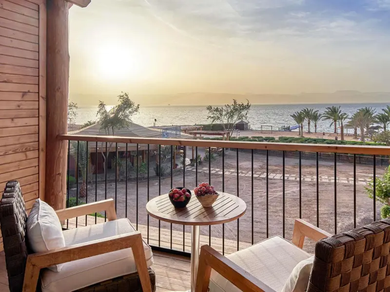 Terrasse avec mobilier d'extérieur donnant sur la mer au lever du soleil.