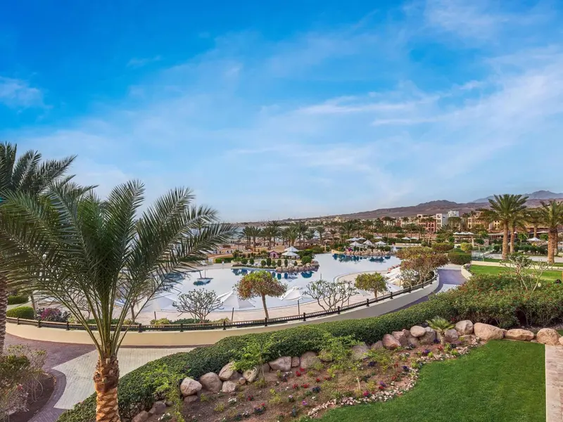 Vue aérienne d'un complexe hôtelier avec piscine et végétation luxuriante.