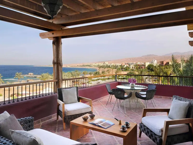 Terrasse aménagée avec salon et table à manger donnant sur la mer et les montagnes.