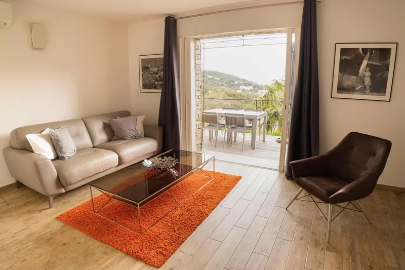 Un salon clair s'ouvre sur une terrasse avec vue sur la mer.