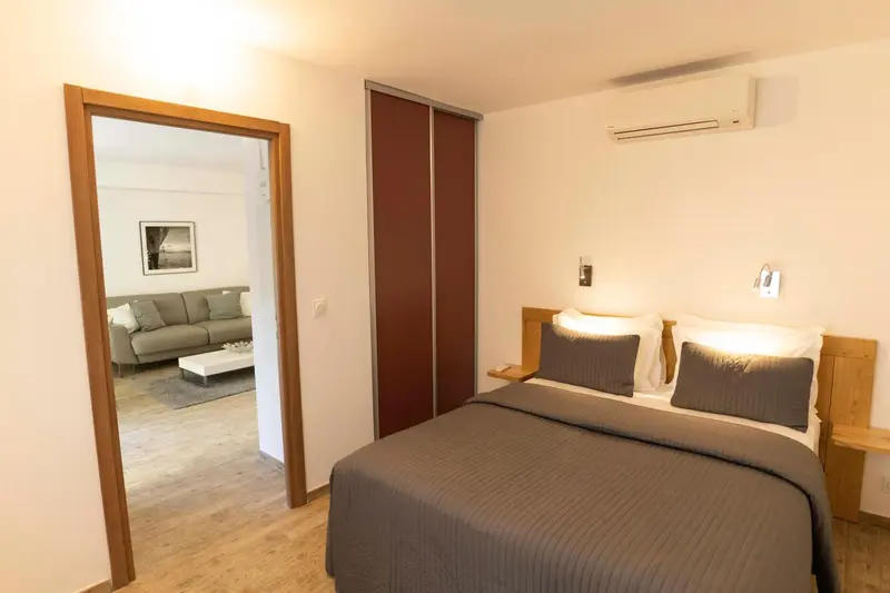 Une chambre lumineuse s'ouvre sur un espace de détente avec canapé.