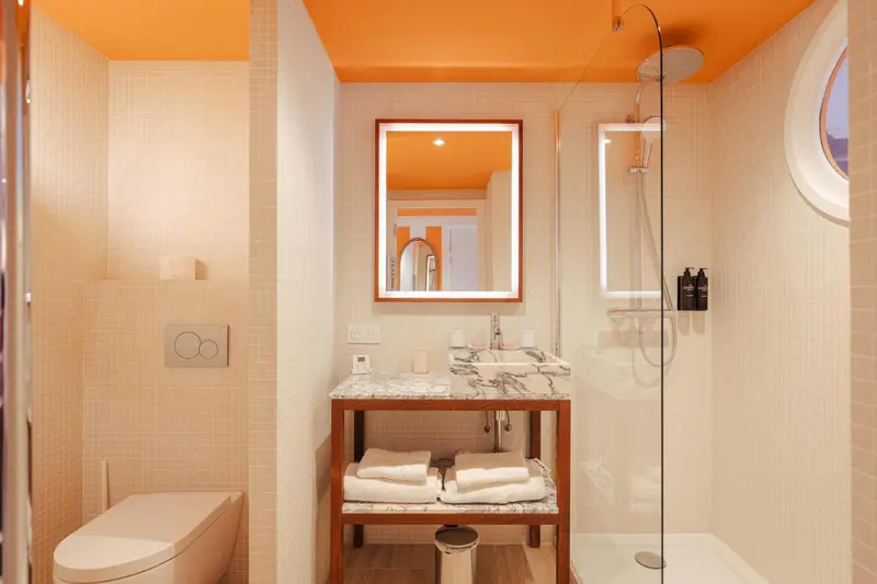 Une salle de bain moderne avec douche à l'italienne et vasque sur meuble.