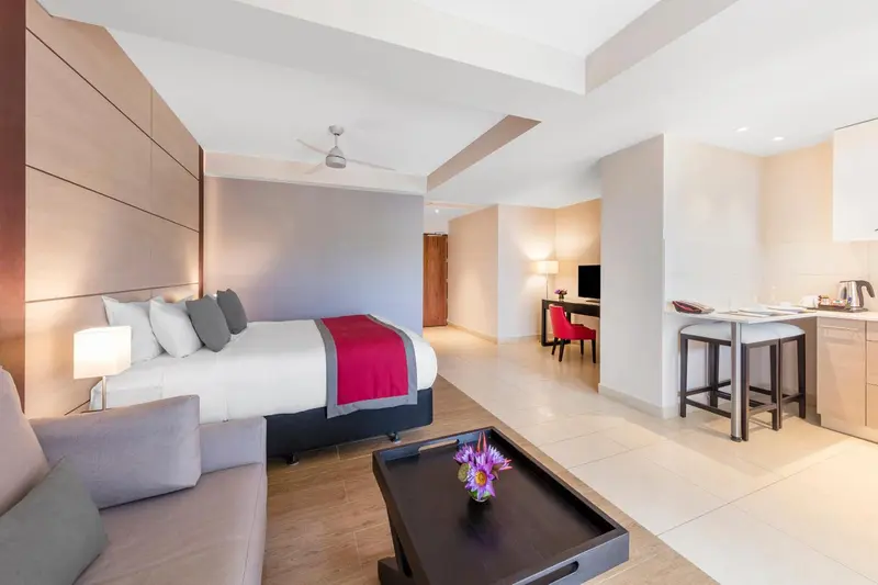 Une chambre lumineuse avec un grand lit et un espace repas.