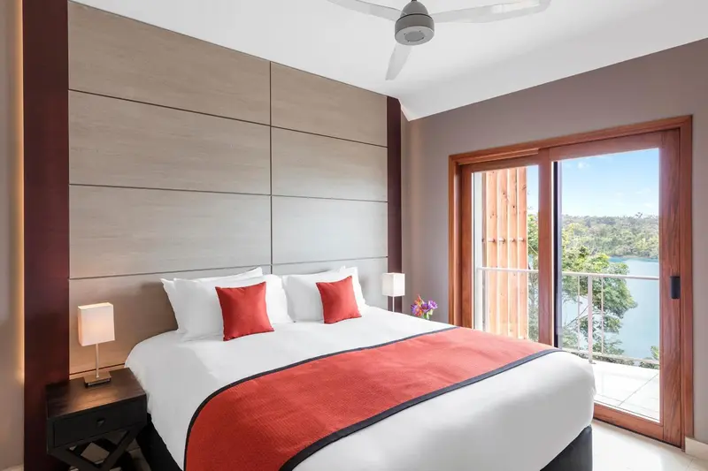 Une chambre lumineuse avec un grand lit et un accès à une terrasse.