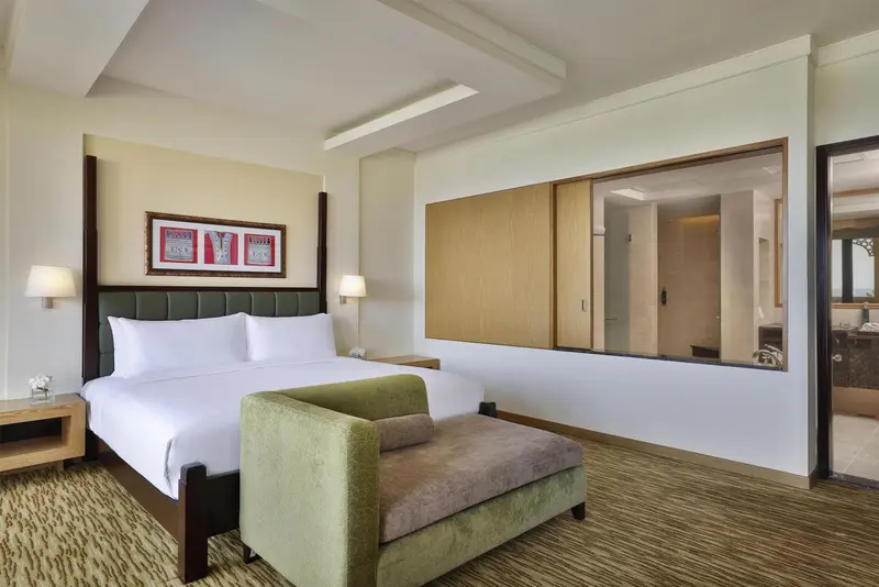 Une chambre lumineuse avec un grand lit et un espace détente.